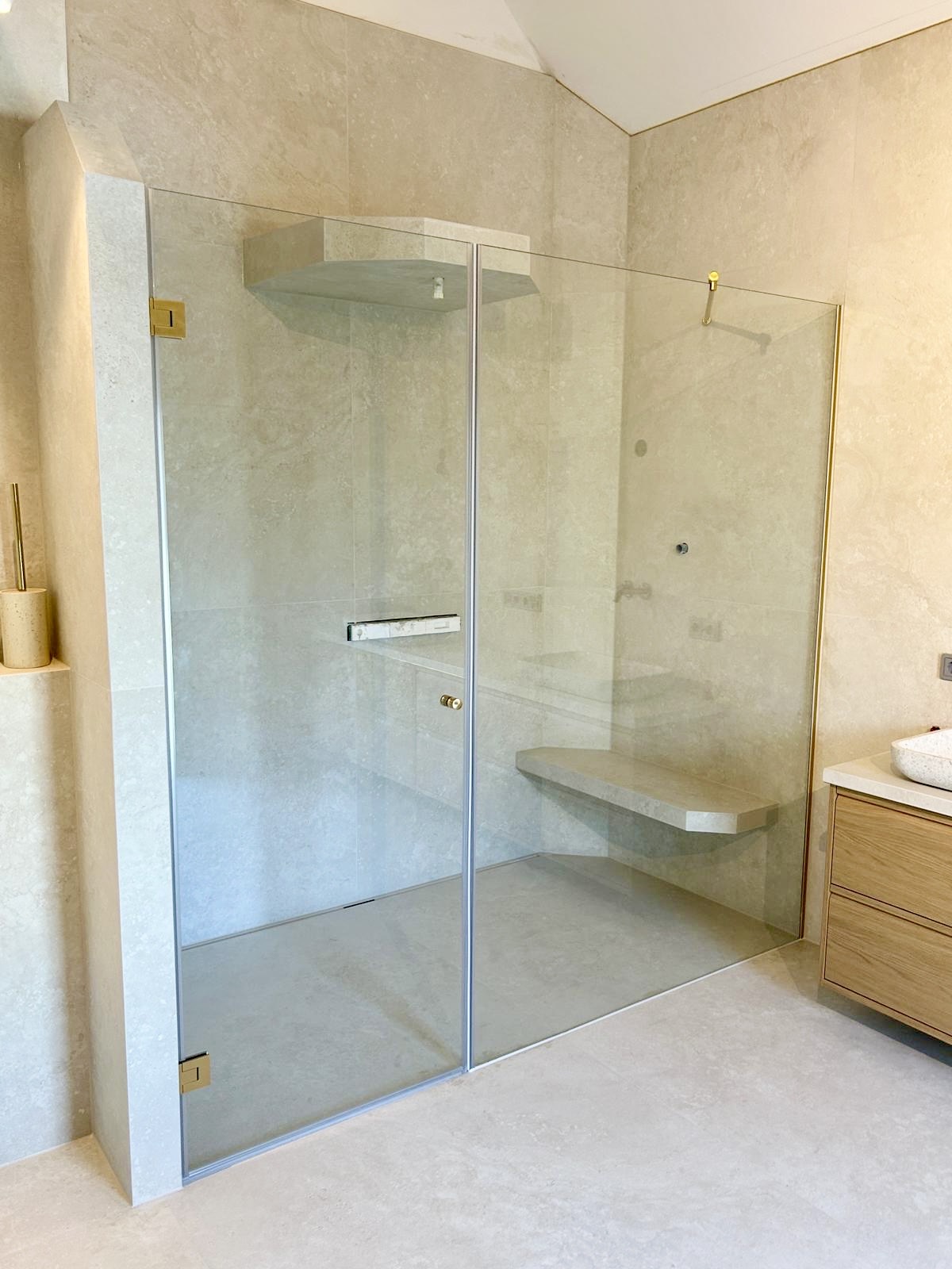 Walk-in Glasdusche mit Sitzbank und Messingbeschlägen unter Dachschräge – Glaserei Rohrig Neusäß bei Augsburg