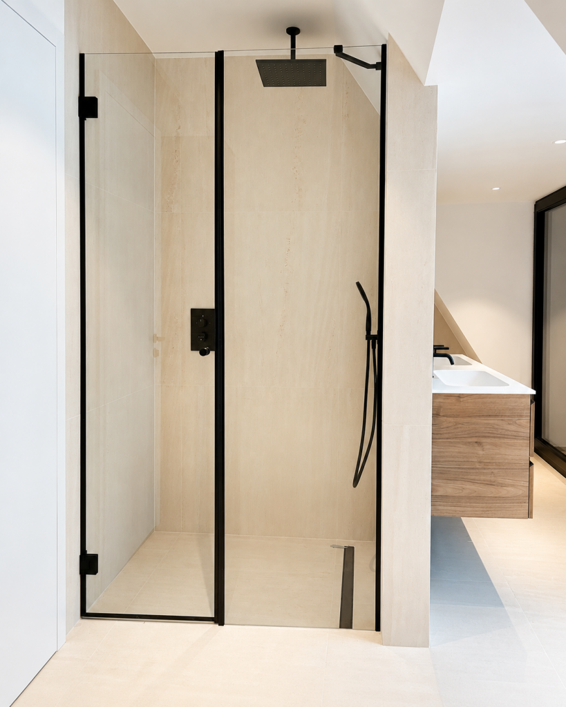 Moderne Glasdusche aus ESG-Glas in hellem Bad mit schwarzen Beschlägen