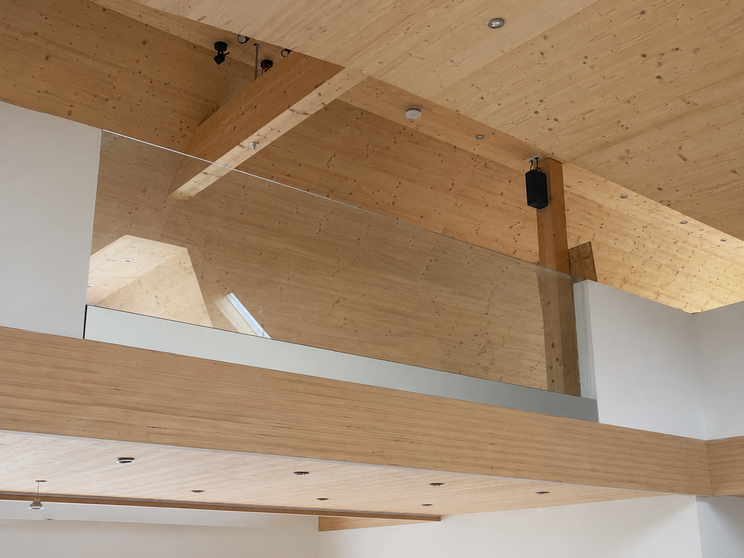 Glasgeländer an Galerie im Innenbereich mit Holzdecke und transparenter Glasfläche