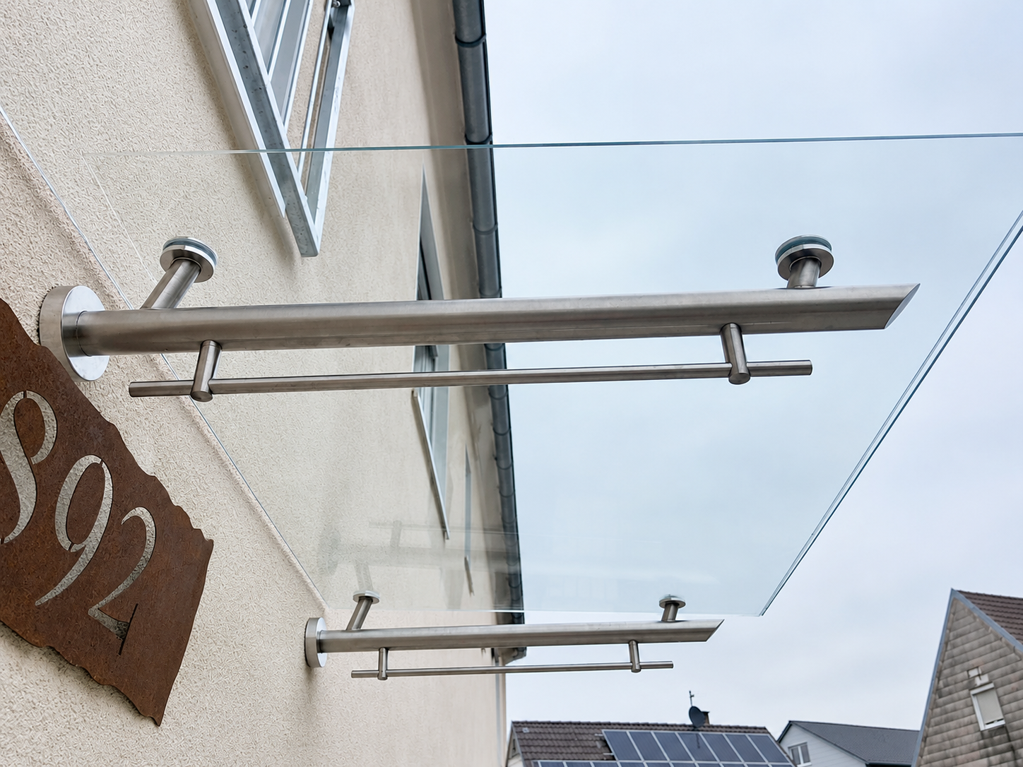 Detail einer Glasüberdachung mit Glaskante und Edelstahlhalterungen